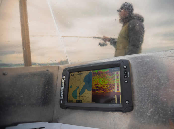 En Lowrance ekolodsskärm visar färgrik sonar och sjökarta med djupangivelser, sportfiskare redo för nästa fiskeresa.