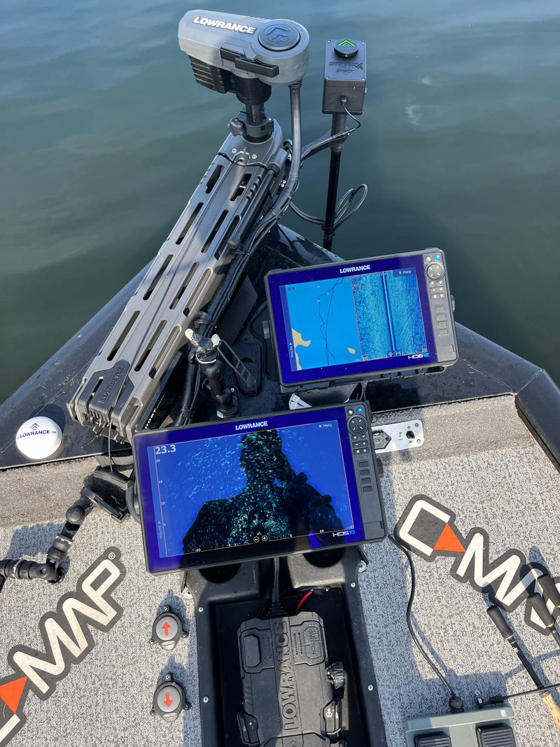 Två ekolod visar sonar- och kartdata på fiskebåtens däck, elmotor vid fören och lugnt vatten-perfekt för sportfiskare.