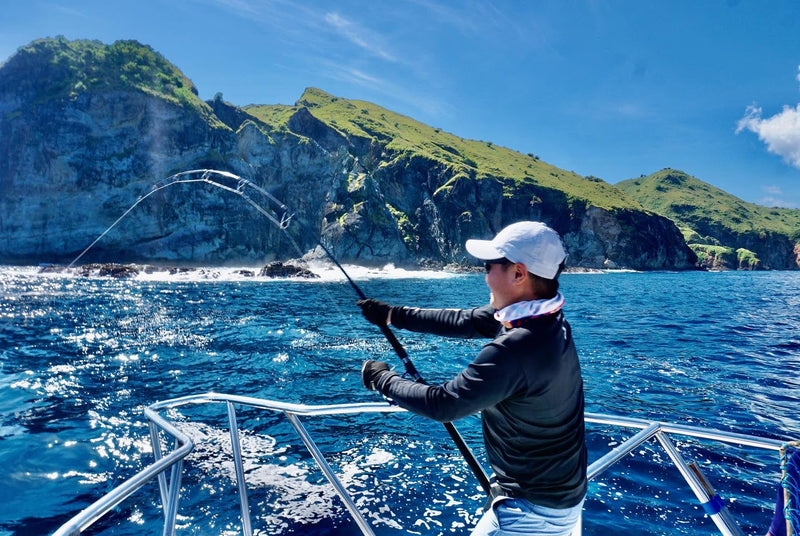 Sportfiskare som fightar en Giant Trevally från båt i Komodo National Park.