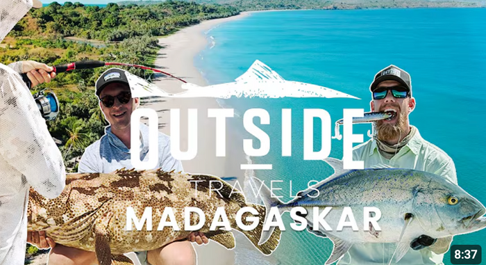 Två sportfiskare visar upp stora fiskar vid tropisk strand med blått vatten. Text: OUTSIDE TRAVELS MADAGASKAR, 8:37.